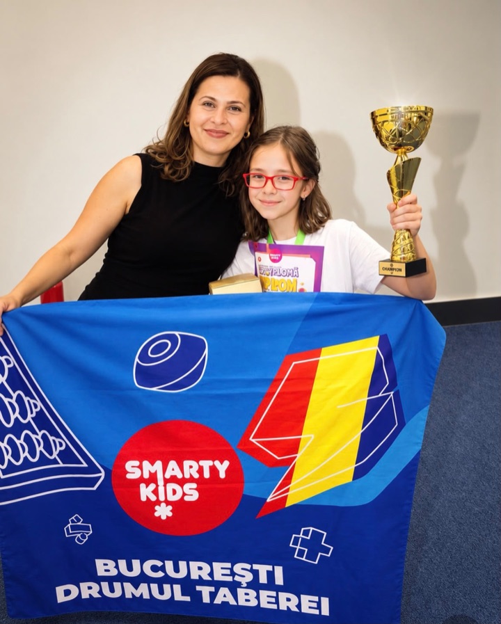 Adelina Gogu cu o elevă SmartyKids Drumul Taberei care ține trofeul de campioană